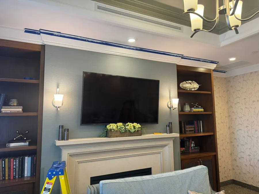 TV mounted on the wall above a fireplace between built-in shelves